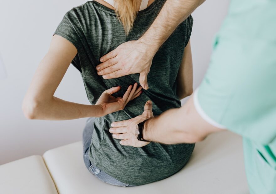 Osteopath performing functional movement assessment and treatment for lower back pain