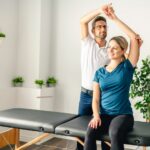 Office worker performing desk stretches for neck, shoulder and back mobility