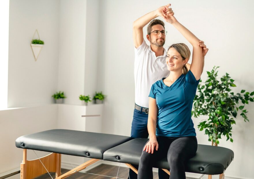 Office worker performing desk stretches for neck, shoulder and back mobility